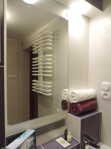 a bathroom with a mirror and a sink and towels at Apartament Violet in Krosno