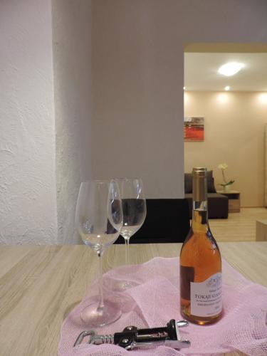 a bottle of wine and a glass on a table at Apartament Violet in Krosno