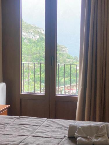 a bedroom with a bed and a window with a view at Hostal Centre Del Montsec in Llimiana