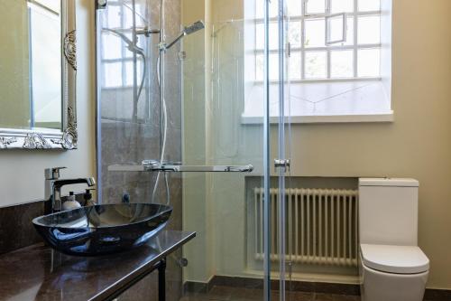 a bathroom with a sink and a glass shower at White Brig Guesthouse in Hudiksvall