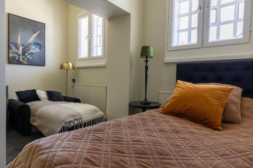 a bedroom with a bed and a chair and windows at White Brig Guesthouse in Hudiksvall