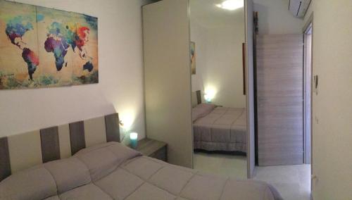 a bedroom with a bed and a mirror and a room with two beds at A.I.R. Badesi Borgo di Mare in Badesi