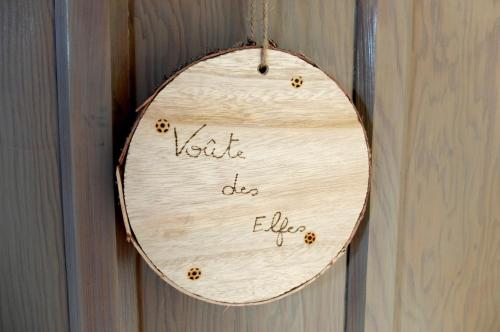 a wooden sign hanging on a wooden wall at Maison d hôtes "Aux Légendes d Ardenne" in Carlsbourg