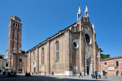 a large brick building with a tower and a church at Ca' San Polo - Ferretti Hotels Collection in Venice