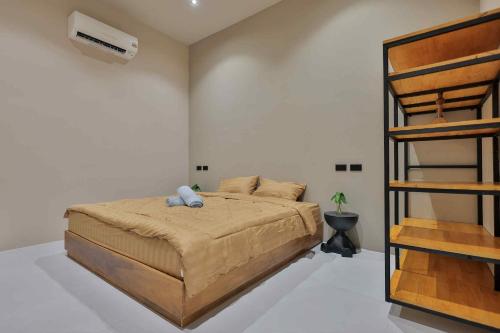 a bedroom with a bed in a room with a fan at De Helga Apartment Chaloklum in Ko Phangan