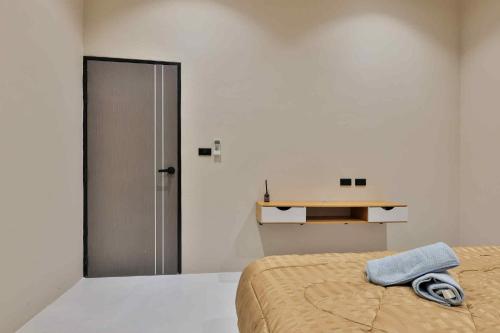 a bedroom with a bed with a towel on it at De Helga Apartment Chaloklum in Ko Phangan