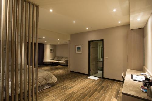 a bedroom with a bed and a living room at VeryGood Business Hotel in Huatan