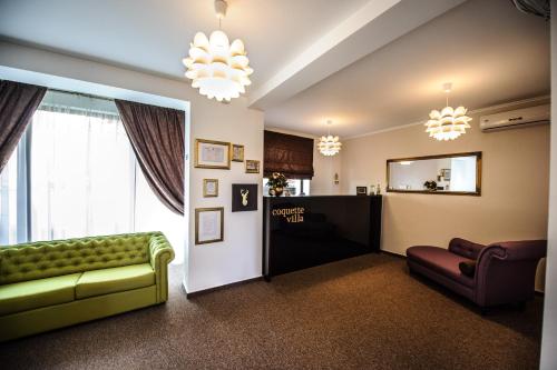 sala de estar con sofá verde y espejo en Coquette VILLA Mamaia Nord, en Mamaia Nord – Năvodari