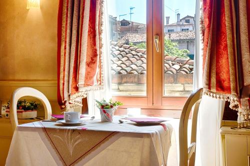 a table and chairs with a table and a window at Ca' San Polo - Ferretti Hotels Collection in Venice