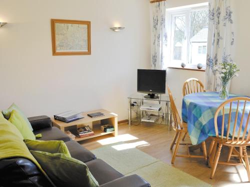 ein Wohnzimmer mit Sofa und Tisch in der Unterkunft Rose Cottage in Winterborne Steepleton