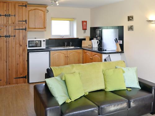 ein Wohnzimmer mit Couch und Küche in der Unterkunft Rose Cottage in Winterborne Steepleton