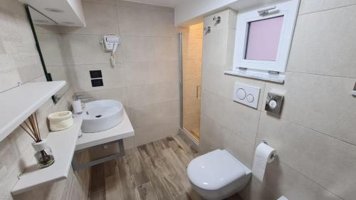 a bathroom with a toilet and a sink and a window at Angel's Care B&B in Reggio Calabria