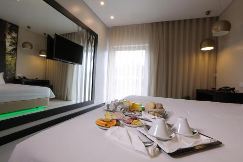 a hotel room with a tray of food on a bed at Lisotel - Hotel & Spa in Leiria