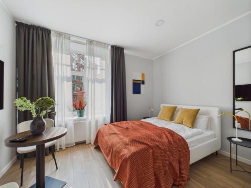 a bedroom with a bed and a table and a window at P6-A Riga Old Town Apartments in Rīga