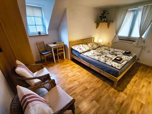 a bedroom with a bed and a table and a couch at Ubytování U Tajčů in Dolní Beřkovice