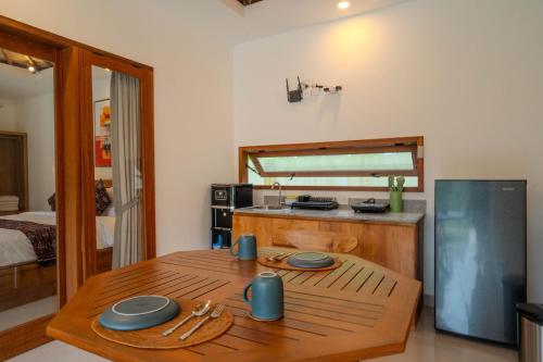 a kitchen with a wooden table in a room at Arca Jungle View Luxury Villa Ubud in Ubud