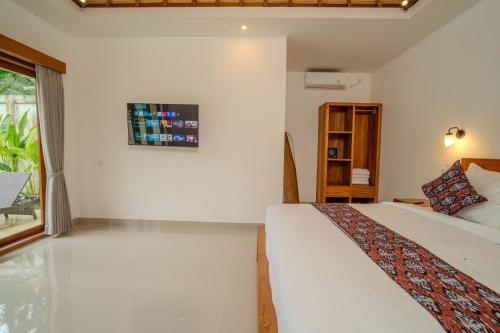 a white bedroom with a bed and a window at Arca Jungle View Luxury Villa Ubud in Ubud