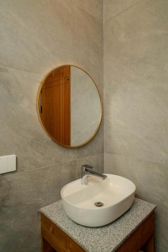 a bathroom with a sink and a mirror at Arca Jungle View Luxury Villa Ubud in Ubud