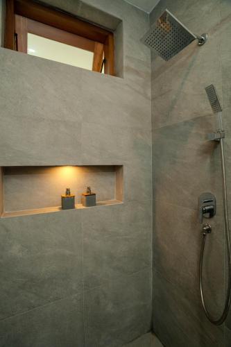 a bathroom with a shower with a glass shower at Arca Jungle View Luxury Villa Ubud in Ubud