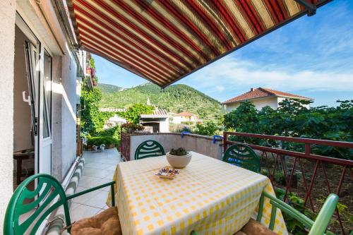 een tafel en stoelen op een balkon met uitzicht bij Garden Apartments in Komiža