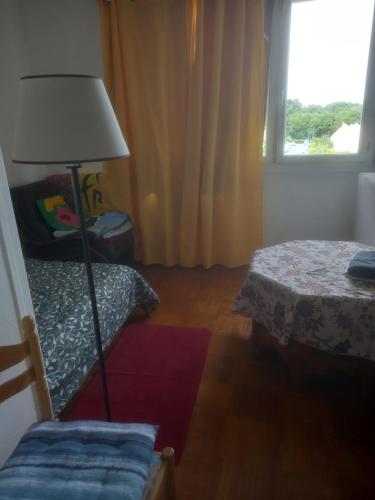 a bedroom with a bed and a lamp and a window at Spacieux appartement 4 pieces in Beauvais