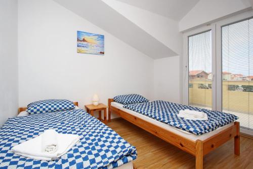 two beds in a room with a window at Apartments Jasmina in Novalja