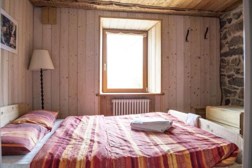 a bedroom with a bed in a room with a window at Rifugio Serot in Roncegno