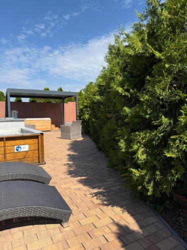 a patio with bushes and a bench and a tree at Apartmány Přítluky in Přítluky