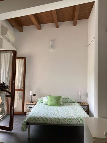a bedroom with a bed with a green pillow at Happy House Montemarciano in Montemarciano