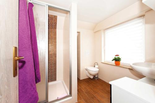 a bathroom with a purple shower curtain and a sink at Ferienwohnung Müller in Hohnstein