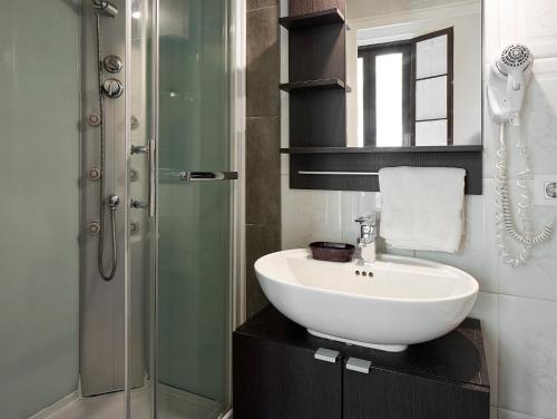 a bathroom with a sink and a glass shower at BruStar Gotic-Centric in Barcelona