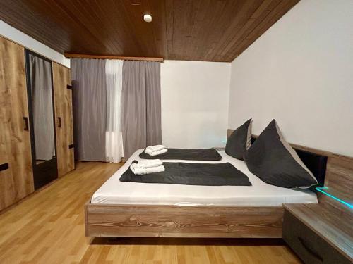 a bedroom with a large bed with black pillows at Wald & Ruhe Kordel in Kordel