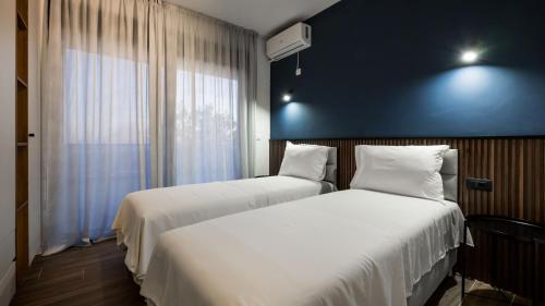 two beds in a room with a blue wall at Villa Amara in Bar