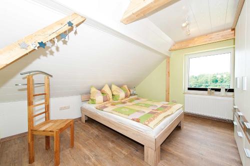 ein Schlafzimmer mit einem Bett, einer Leiter und einem Fenster in der Unterkunft Ferienwohnung Müller in Hohnstein