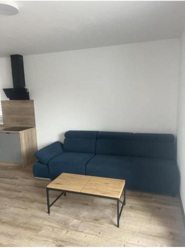 a blue couch in a living room with a coffee table at Apartmán Bobrov 2 in Bobrów