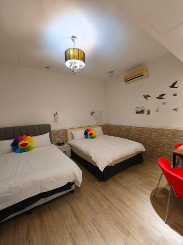 a bedroom with two beds and a red chair at Good 9 Stay Inn in Taipei