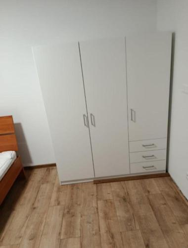 a bedroom with white cabinets and a wooden floor at Apartmán Bobrov 2 in Bobrów