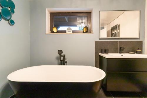 un baño con bañera y lavabo en Lütt Heidjer Hus, en Buchholz in der Nordheide
