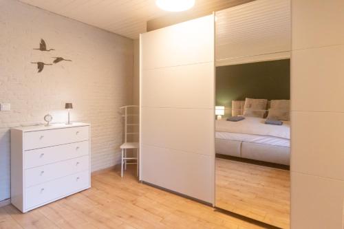 Un dormitorio con una cama y un espejo grande. en Lütt Heidjer Hus, en Buchholz in der Nordheide