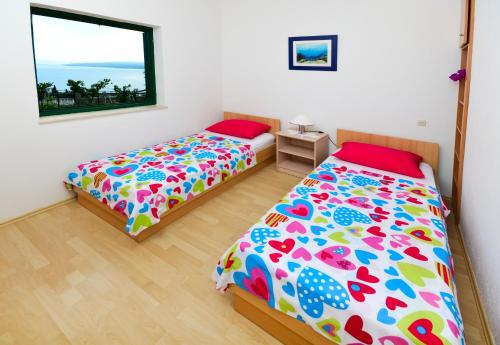 a bedroom with two beds and a window at Vila Dunja in Makarska
