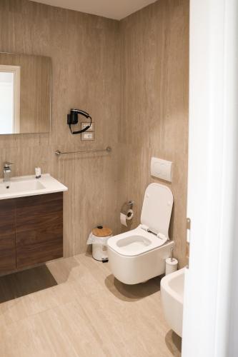 a bathroom with a white toilet and a sink at Hotel Platinium Dhermi in Vlorë
