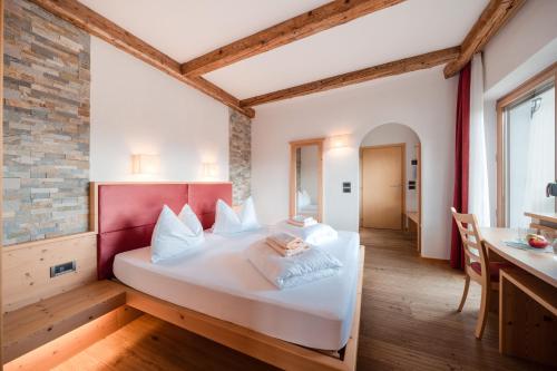 アンテルモイアにあるHotel Pütiaのベッドルーム1室(白いベッド1台、赤いヘッドボード付)