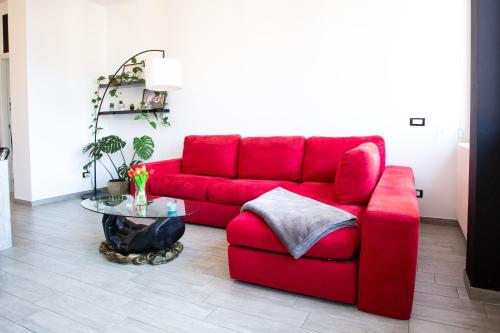 a red couch in a living room with a table at Honey House - vista lago e montagne in Luino