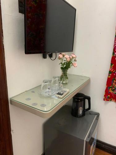 a glass shelf on a wall with a tv on it at Sword Lake hostel in Hanoi