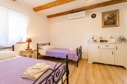 a bedroom with two beds and a dresser at Old house Rustica with pool, jacuzzi and tavern - Valincic in Brinje