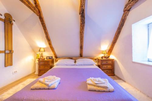 a bedroom with a bed with two towels on it at Old house Rustica with pool, jacuzzi and tavern - Valincic in Brinje