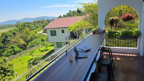 a laptop sitting on top of a deck on a house at KK Sunset Villa- Full Sunset Balcony, Mosquito Free, 4K TVs, 5G WIFI and more! in Kota Kinabalu