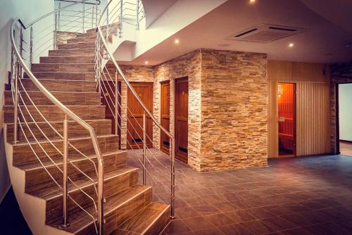 a spiral staircase in a building with a stone wall at Hotel Perla in Slănic-Moldova