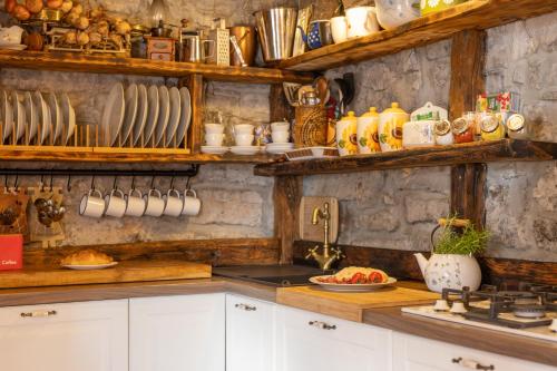 a kitchen with white cabinets and a counter with dishes at Old house Rustica with pool, jacuzzi and tavern - Valincic in Brinje