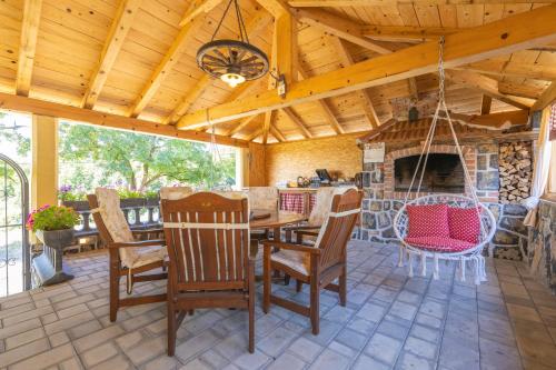 a porch with a table and chairs and a fireplace at Old house Rustica with pool, jacuzzi and tavern - Valincic in Brinje